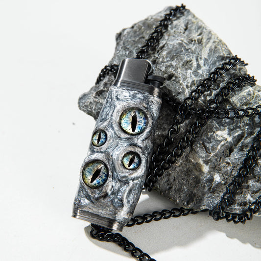 Mellow Sora dragon eye lighter case with black chain on stone, unique lighter accessory