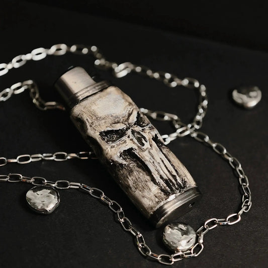 Skull-themed lighter case with chain, Mellow Sora unique metallic accessory on black surface