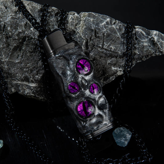 Mellow Sora skull lighter case with purple gem eyes on black chain, stone background