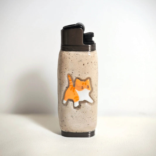 Beige ceramic lighter case with orange cat design, Mellow Sora accessory on white background.
