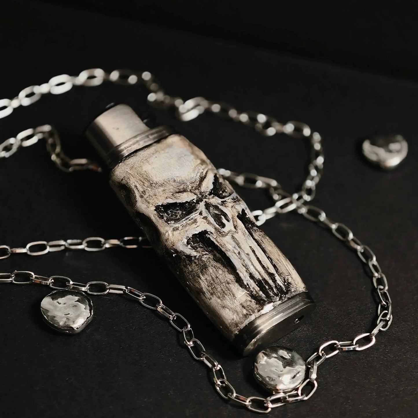 Skull-themed lighter case with chain, Mellow Sora unique metallic accessory on black surface