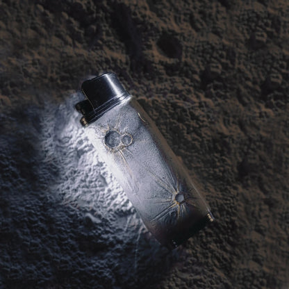 Silver lighter case with sunburst engravings on textured stone, Mellow Sora accessory