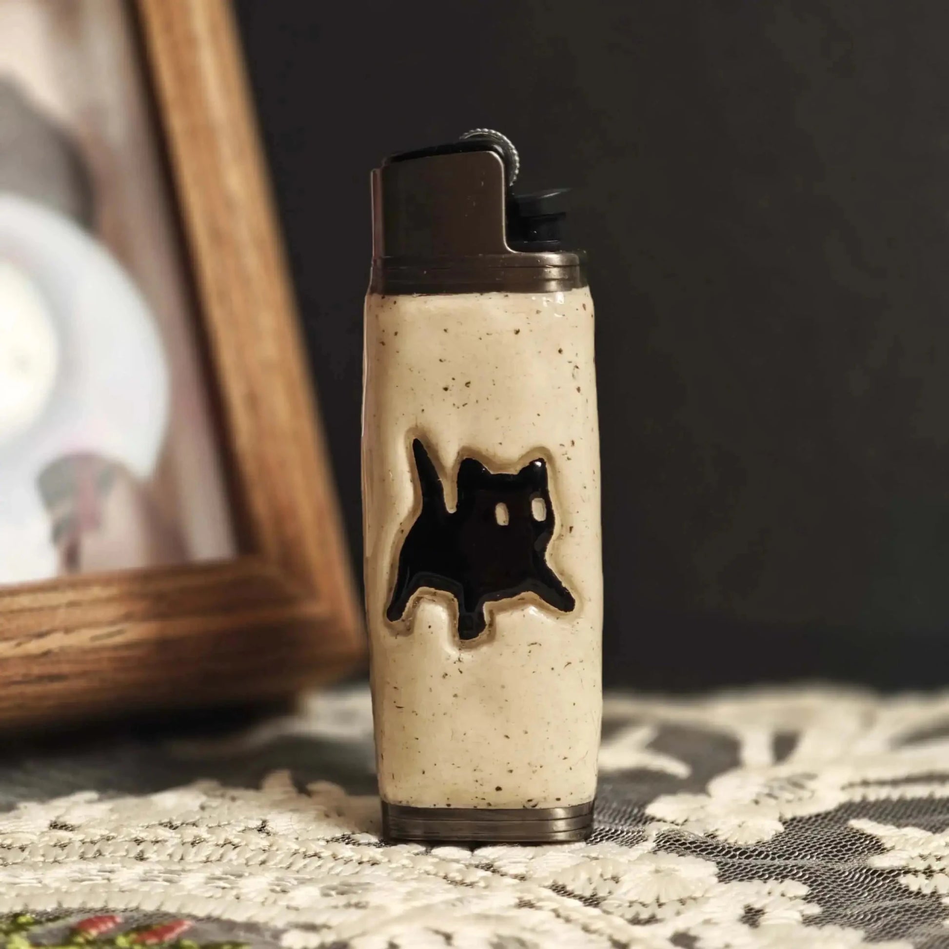 Ceramic lighter case with black cat design on lace table, Mellow Sora lifestyle accessory